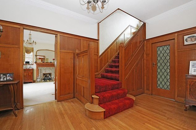 The property boasts a wood-panelled hallway, a reception room with a grand ornate fireplace that looks out onto a large back garden, and a tiled modern kitchen complete with spacious breakfast area