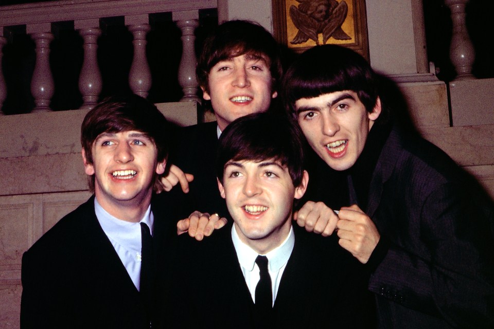 The Beatles pose for a portrait in suits: Ringo Starr, John Lennon, Paul McCartney, and George Harrison.