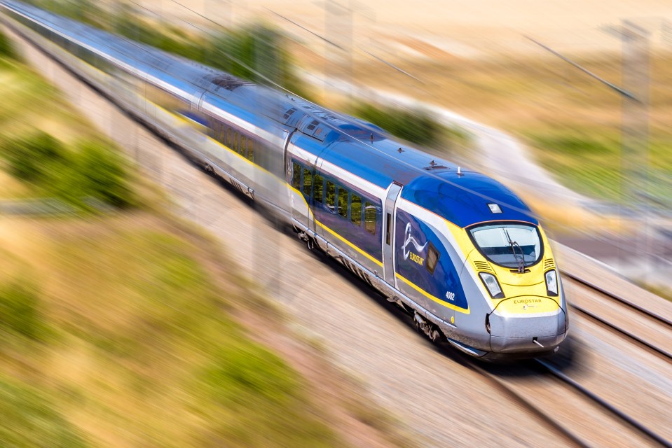Illustration of a Eurostar e320 high-speed train in blue, yellow, and silver, speeding through the French countryside with blurred motion.