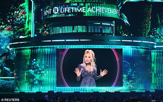 She went on to say that she knew her late husband would be looking down on them and how he hated speeches (Dolly Parton pictured)