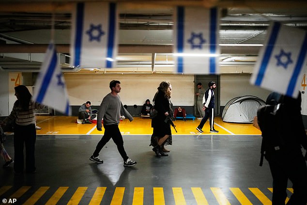 People take shelter in an underground parking garage as air raid sirens warn of incoming missiles strike by Iran, in Tel Aviv, Israel, on Saturday February 28, 2026