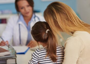 A mother and daughter confer with a doctor.