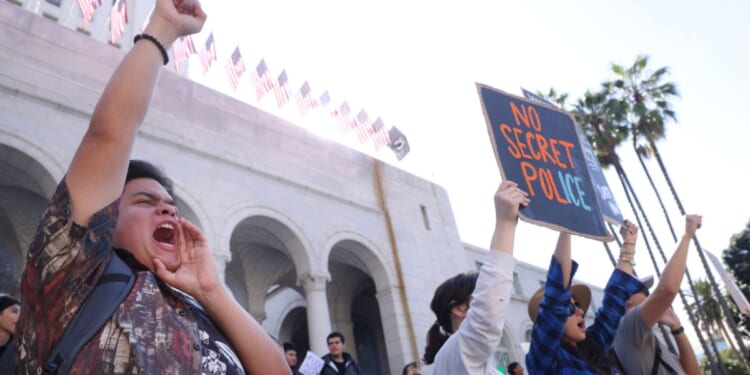 Teacher Andre Lopez, left, from Duarte Elementary School, joins activists and protesters take part in an "ICE Out of Everywhere" protest in front of City Hall in downtown Los Angeles on Jan. 30, 2026.