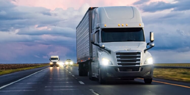 A stock photo of a tractor-trailer rolling down a highway.