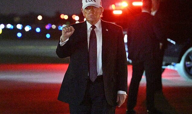 US President Donald Trump makes a fist after he steps off Air Force One upon arrival at Palm Beach
