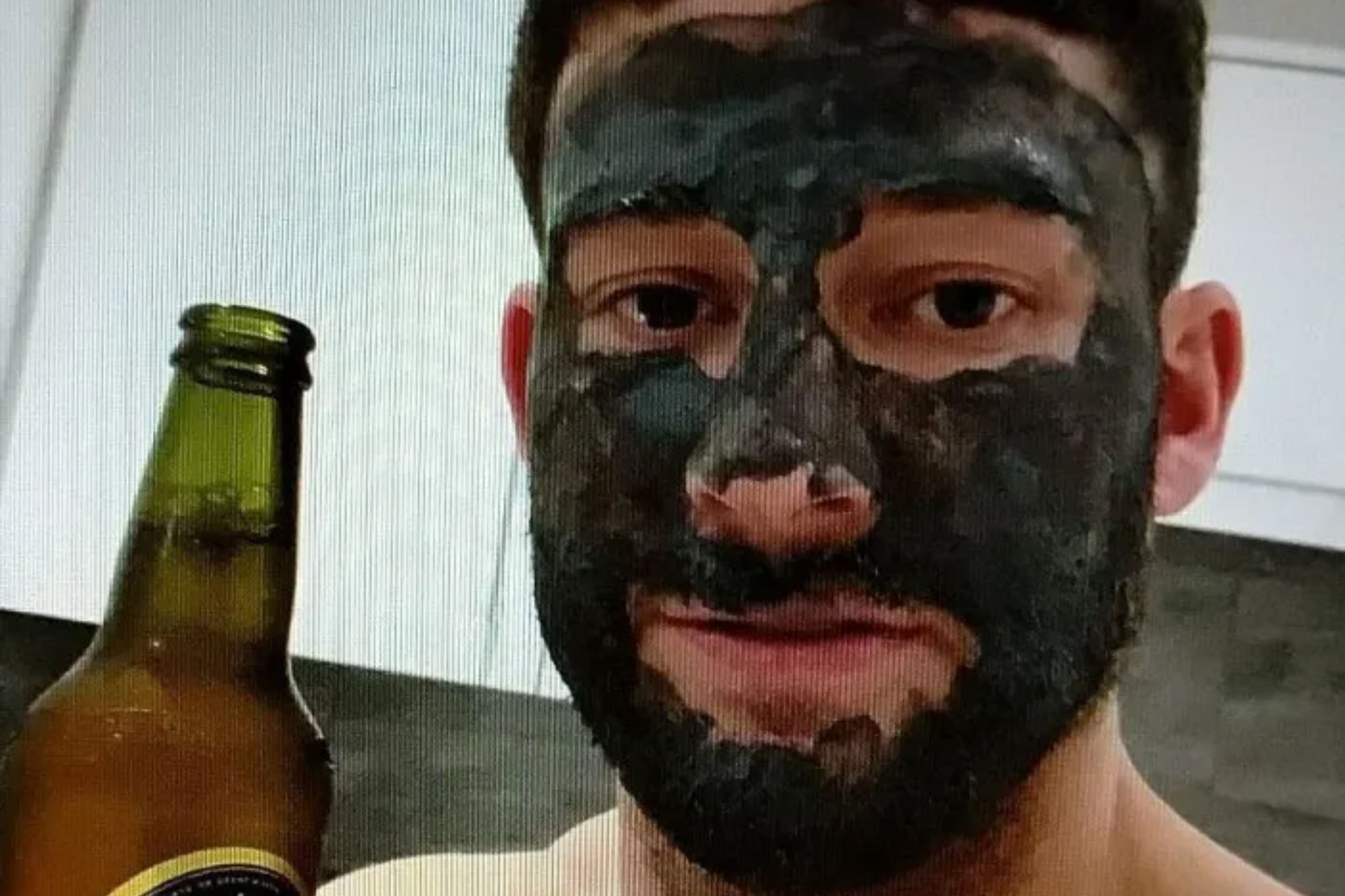 An image collage containing 1 images, Image 1 shows A man with a black face mask and beard holds a bottle of cider