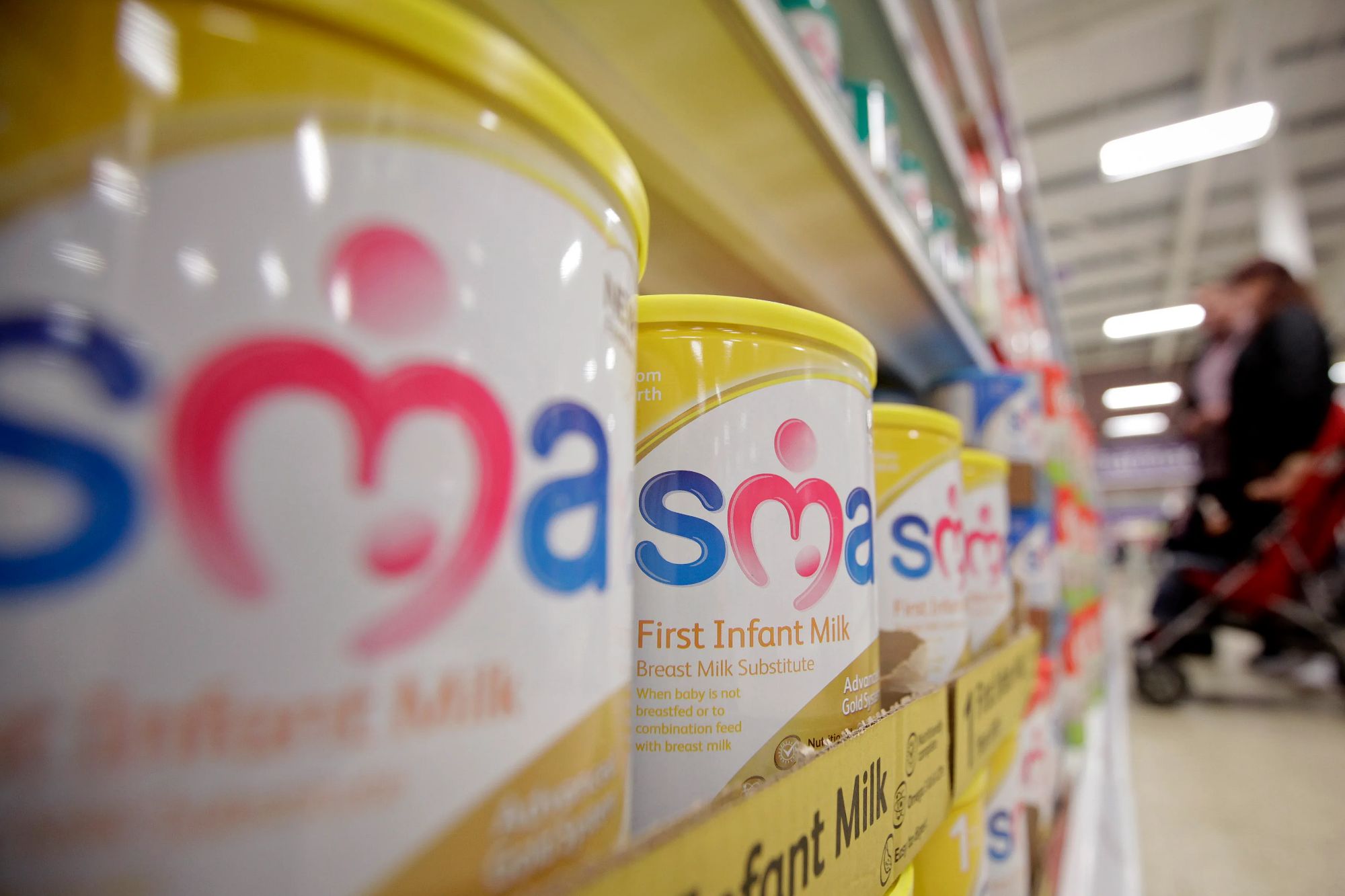 An image collage containing 1 images, Image 1 shows Tins of SMA powdered infant formula are displayed for sale in a supermarket