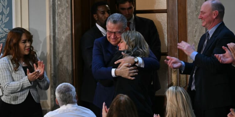Former Venezuelan presidential candidate and recently released prisoner Enrique Márquez embraces a family member as he is being recognized by President Donald Trump at the State of the Union address in the House Chamber of the US Capitol in Washington, DC on Feb. 24, 2026.
