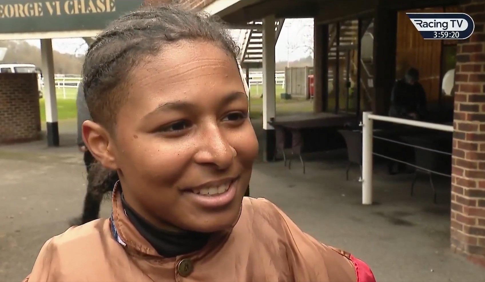 Close-up of a female jockey smiling and looking to the right.