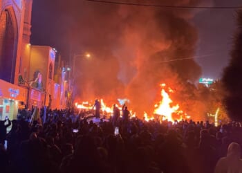 Iranian protesters gather around burning cars near a mosque while blocking a street during a protest in Tehran, Iran, on Jan. 8. The nationwide demonstrations spread across cities with slogans turning from economic grievances to political and anti-government calls. The protests were met by a violent crackdown in which thousands were reportedly killed, according to human rights groups.