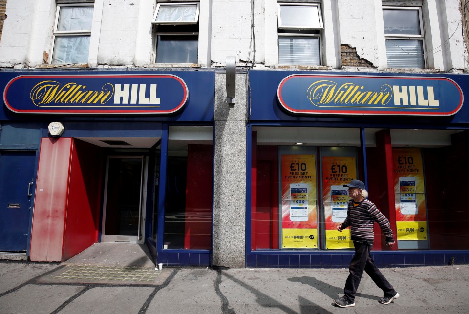 A pedestrian walks past a William Hill betting shop in London.