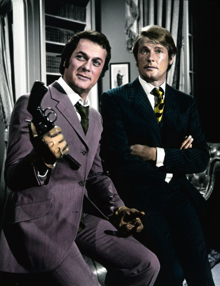 Tony Curtis and Roger Moore sitting together, with Curtis holding a pistol.