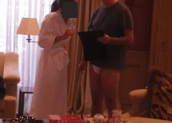 A photograph released as part of the Epstein files apparently shows Lord Mandelson talking to a woman who is wearing a white bath robe