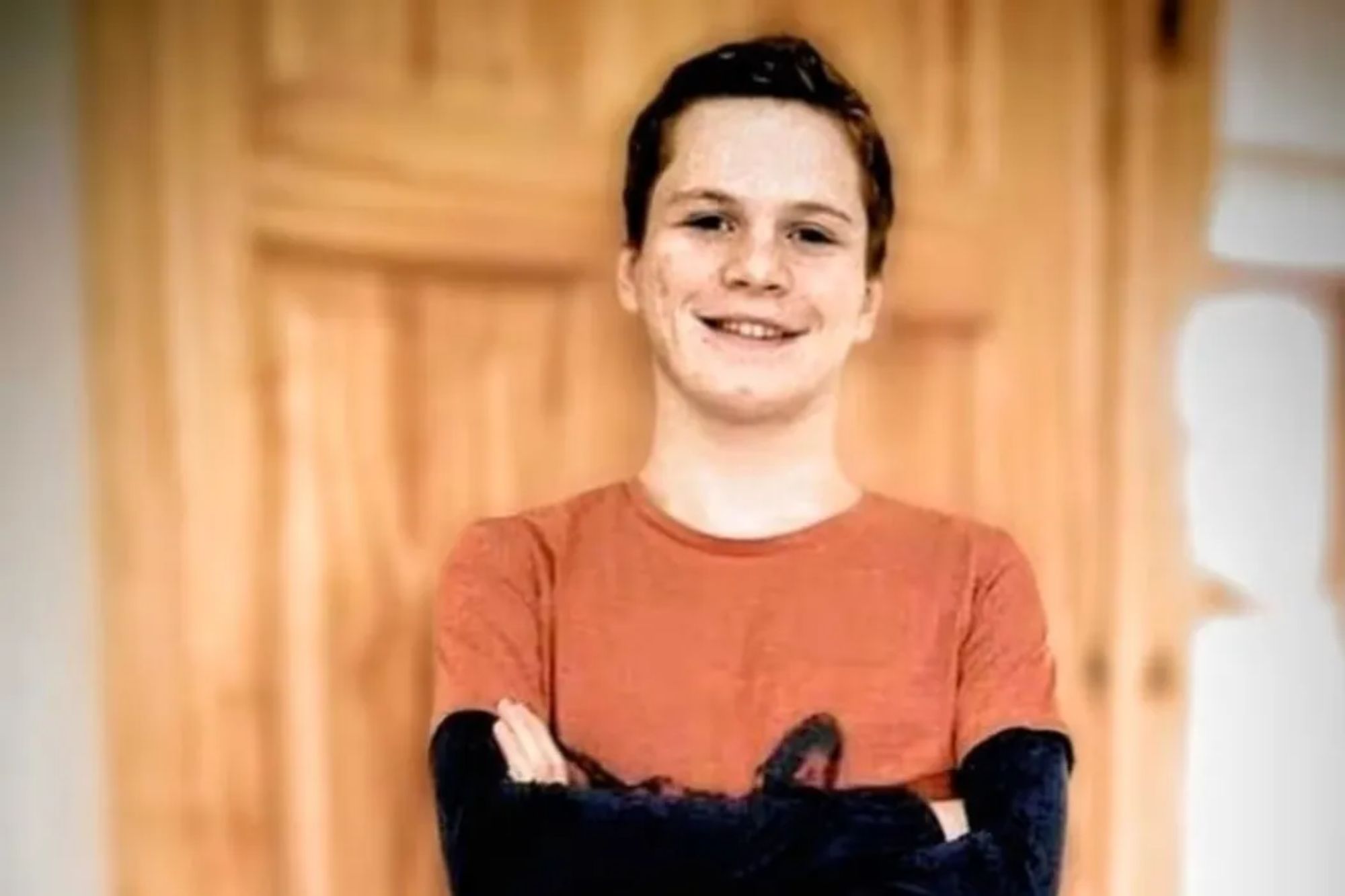 An image collage containing 1 images, Image 1 shows A smiling young man with short brown hair and an orange shirt crosses his arms