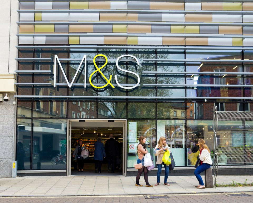Exterior of a Marks & Spencer department store with shoppers entering and exiting.