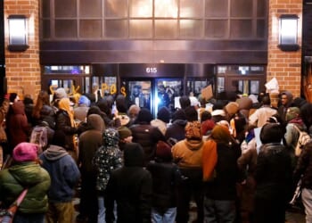 Anti-ICE demonstrators protest outside the graffiti-tagged Graduate Hotel, where federal immigration agents are believed to be staying in Minneapolis, Minnesota, on Jan. 13, 2026.
