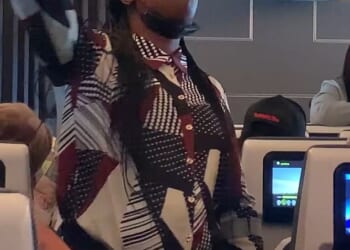 One woman (pictured) stood in the aisle, singing, waving and shouting at passengers until they joined in