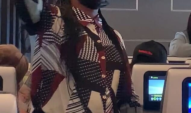 One woman (pictured) stood in the aisle, singing, waving and shouting at passengers until they joined in