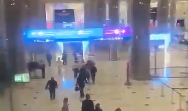 Dramatic footage shows passengers at Dubai's primary international airport fleeing the airport following reports of a strike on one of its terminals