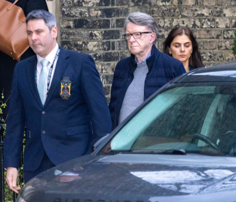 Peter Mandelson leaving his London home accompanied by police officers.