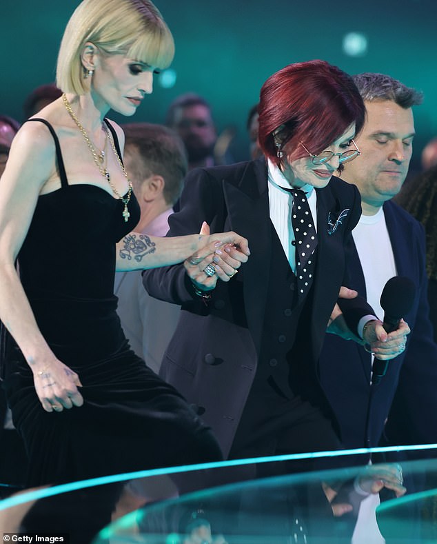 The pair were introduced to the stage by Dolly Parton , who appeared in a pre-recorded, ahead of Robbie Williams' performance with members of Ozzy's band.