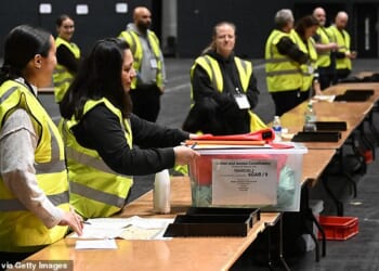Officials are pictured receiving votes for counting in the Gorton and Denton by-election after polls closed at 10pm on Thursday