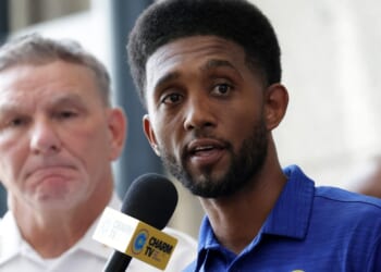 Baltimore Mayor Brandon Scott speaks as Acting Baltimore Police Commissioner Richard Worley listens during a news conference at the police headquarters on July 3, 2023, in Baltimore, Maryland.