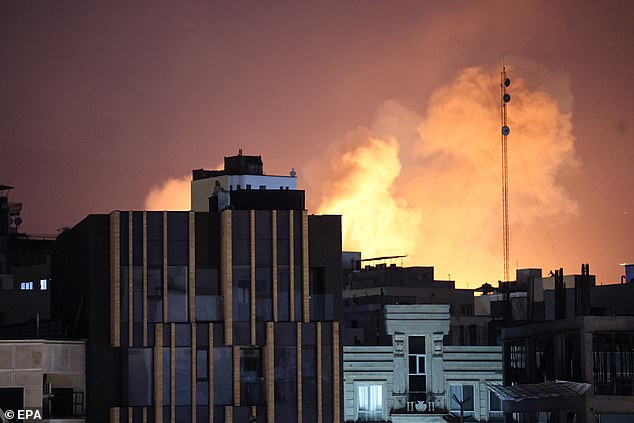 Smoke and flames rise behind buildings after an explosion in Tehran, Iran on the second consecutive day of strikes by US and Israeli forces. President Donald Trump told the Daily Mail that he expected the fighting to go on for four weeks'