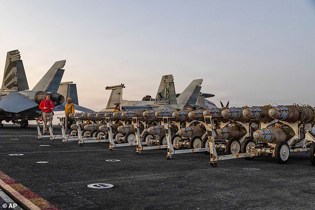 This image provided by U.S. Central Command shows Navy sailors transferring ordnance on the flight deck of Nimitz-class aircraft carrier USS Abraham Lincoln (CVN 72) on Friday