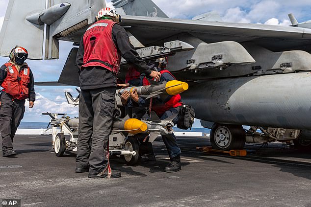 This image provided by U.S. Central Command shows Navy sailors attaching ordnance onto a F/A-18E Super Hornet aircraft on the USS Gerald R. Ford (CVN 78) in support of Operation Epic Fury, on Sunday