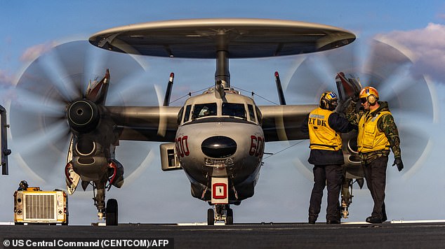 This US Navy photo released by US Central Command public affairs shows US Navy sailors signaling to an E-2D Hawkeye aircraft, attached to Airborne Command and Control Squadron 124, as it taxis on the flight deck of world's largest aircraft carrier, USS Gerald R. Ford (CVN 78), in support of Operation Epic Fury, from an undisclosed location on February 28