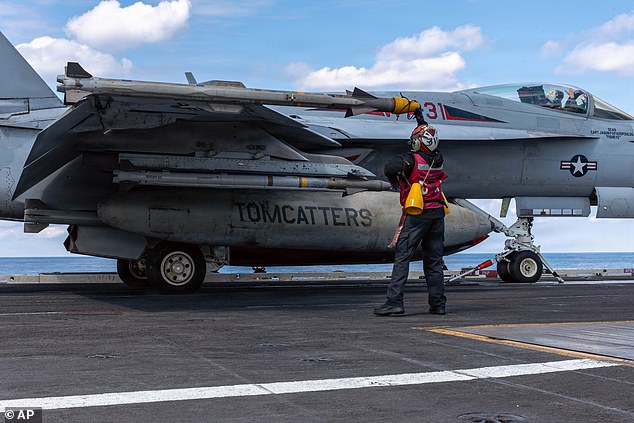 This image provided by U.S. Central Command shows a Navy sailor removing a protective cone from ordnance on a F/A-18E Super Hornet aircraft on the USS Gerald R. Ford (CVN 78) in support of Operation Epic Fury, on Sunday
