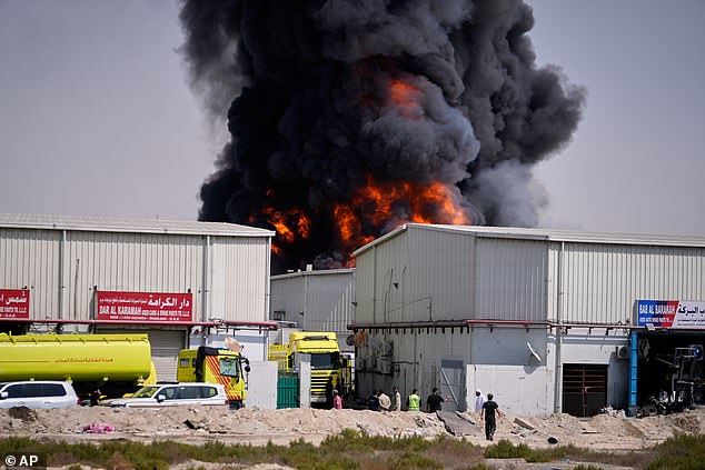 Flames and a black plume of smoke rise from a warehouse in the industrial area of Sharjah City in the UAE, following reports of Iranian strikes