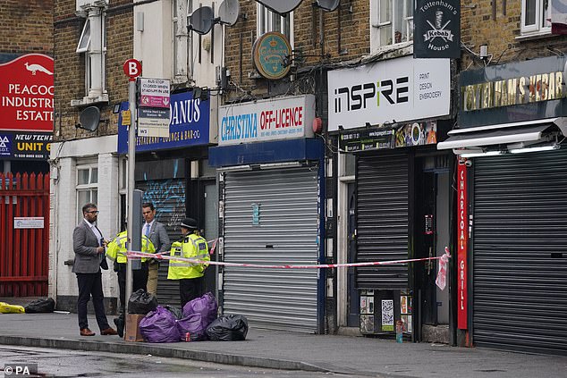 Police pictured at the scene on White Hart Lane in Tottenham following the shooting of Talip Guzel. The Turkish social club was located above a shop on the high street