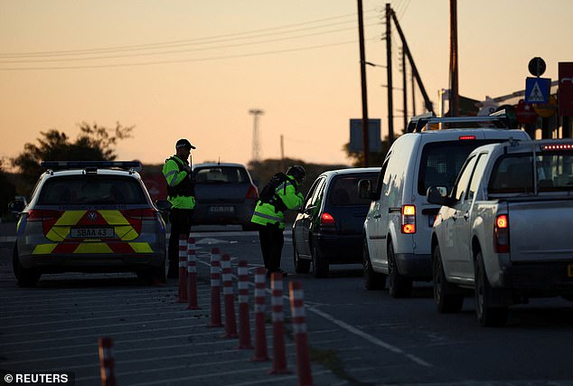 Police carry out road checks on cars heading towards RAF Akrotiri, a British sovereign base in Cyprus, on Monday morning after it was hit by an unmanned drone overnight