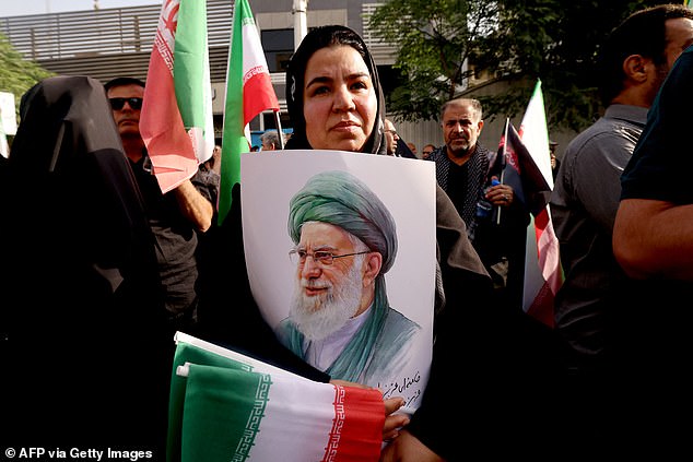 A mourner holds up a poster showing the image of Iran's Supreme Leader Ali Khamenei during the funeral of the Iranian Revolutionary Guards commander and other military commanders killed in Israeli strikes on Iran