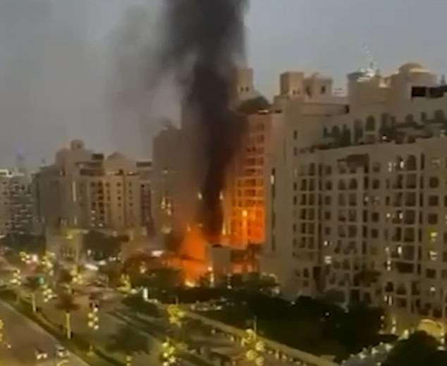 Flames and smoke climb into the sky from Fairmont The Palm hotel after being struck