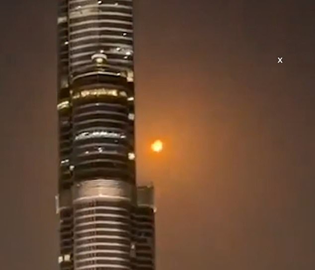 A missile or drone burns up as it is intercepted in the sky next to the Burj Khalifa in Dubai