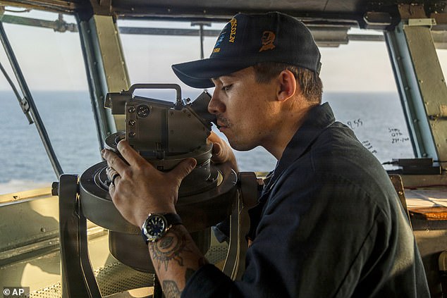 This image provided by U.S. Central Command shows a Navy sailor standing watch on the bridge of the USS Abraham Lincoln (CVN 72) in support of Operation Epic Fury on Sunday