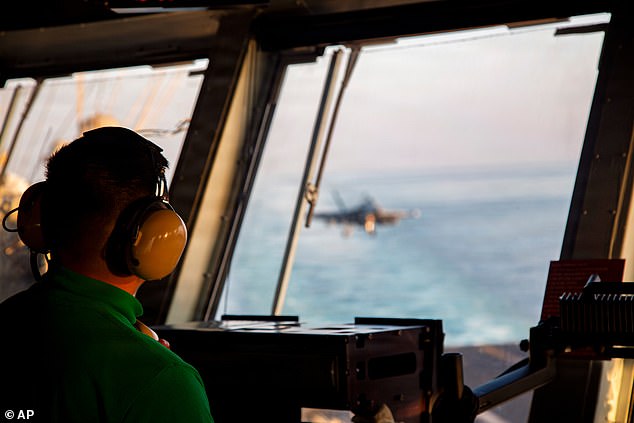 This image provided by U.S. Central Command shows a Navy sailor observing flight operations aboard the USS Abraham Lincoln (CVN 72)) in support of Operation Epic Fury, on Saturday