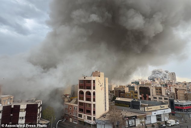 Plumes of smoke from two simultaneous strikes rise over Tehran, Iran, on Monday