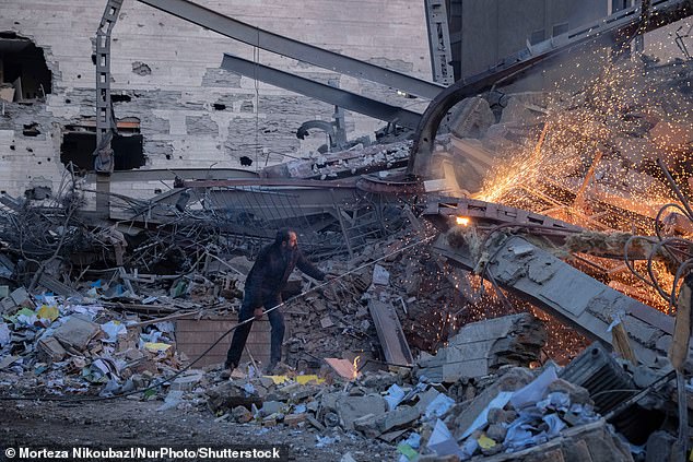 An Iranian man works on the ruins of a police headquarters that is completely destroyed in U.S.-Israeli attacks in Tehran