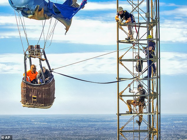 Footage saw both occupants being secured with rope and given hard hats for their descent to the ground far below them