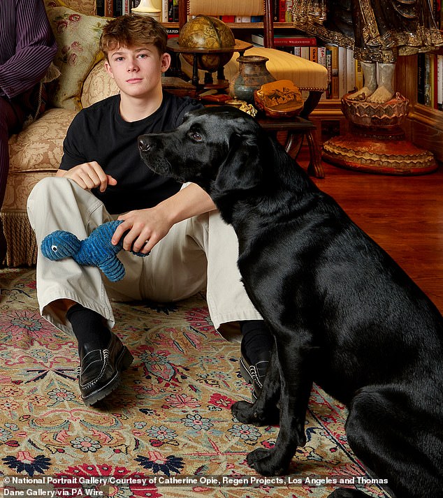 Zachary, who sat on the floor besides one of the black Labradors, clutched a dog toy from Pets at Home. The cord dinosaur toy is currently out of stock online