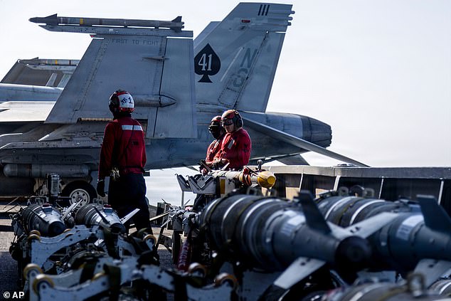 This image provided by U.S. Central Command shows Navy sailors looking over ordnance on the flight deck of the USS Abraham Lincoln (CVN 72) in support of Operation Epic Fury on Monday, March 2