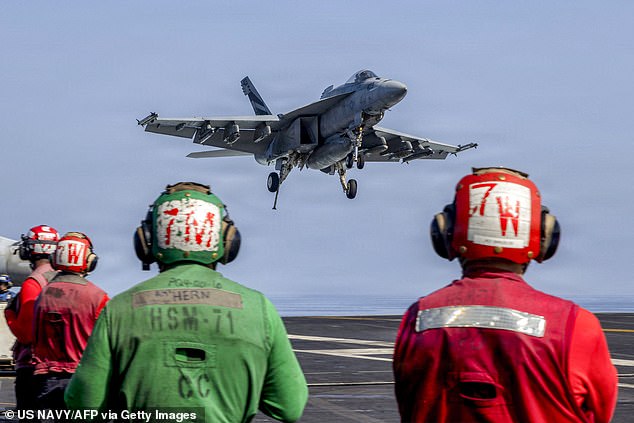 This US Navy handout photo released by US Central Command public affairs shows an F/A-18E Super Hornet, attached to Strike Fighter Squadron (VFA) 151, preparing to make an arrested landing on the flight deck of Nimitz-class aircraft carrier USS Abraham Lincoln (CVN 72) in support of Operation Epic Fury on March 2