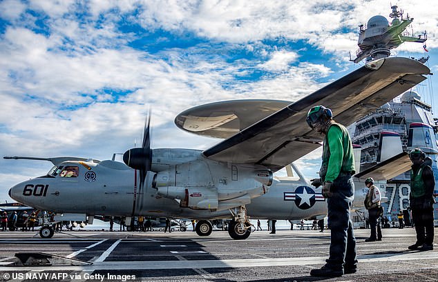 This US Navy handout photo released by US Central Command public affairs shows US Sailors observing as an E-2D Hawkeye aircraft, attached to Airborne Command and Control Squadron 124, approaches an aircraft catapult to launch from the flight deck of the world's largest aircraft carrier, USS Gerald R. Ford (CVN 78), while operating in support of Operation Epic Fury, on March 1