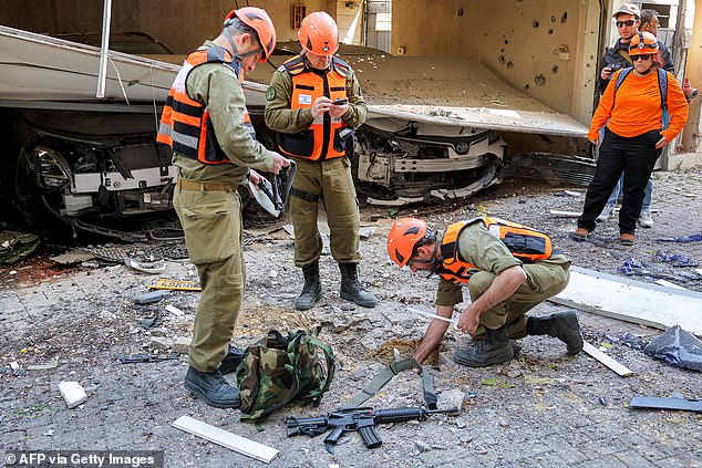 Security personnel conduct a search after a projectile hit the area of Petah Tikva in central Israel on March 3