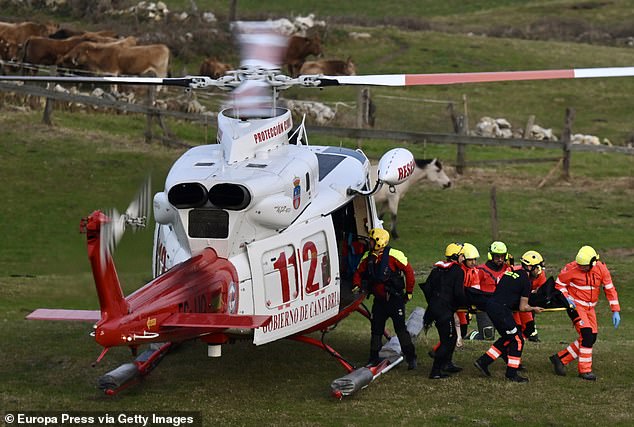 They all fell into the water and onto rocks below the wooden bridge, which is understood to have stretched between two cliffs, when it gave way. Pictured: Rescue teams at the scene