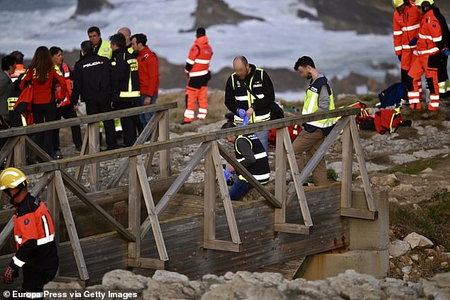 Emergency services (pictured, at the scene) were called by horrified bystanders around fifteen minutes after the walkers fell into the water